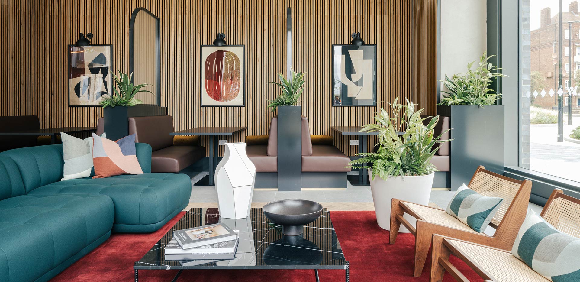 Residents’ lounge with sofas and a communal table at Woodberry Down