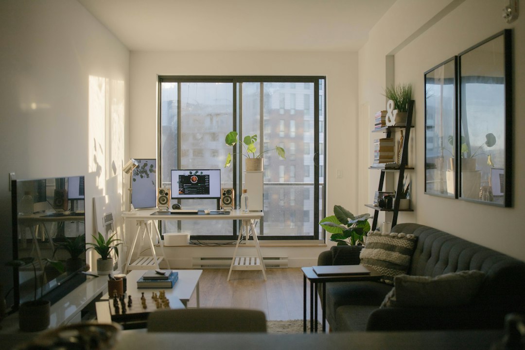 Bright furnished living space with a sofa, plants and a work area